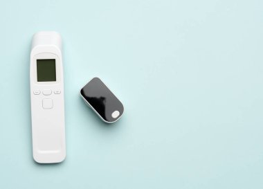 Plastik beyaz elektronik temas olmayan termometre ve kan oksijen ölçer, mavi arkaplan