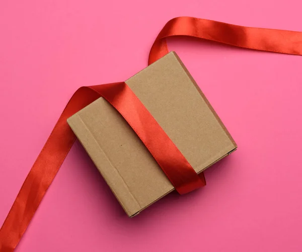 Gift Wrapped Brown Kraft Paper Red Ribbon Pink Background Top — Stock Photo, Image