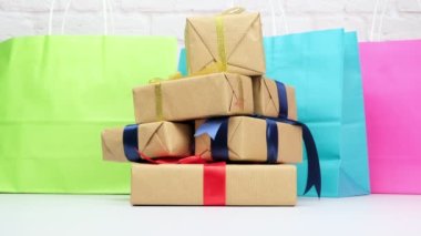 Kahverengi kağıda sarılı dikdörtgen hediye kutusu ve ipek bir kurdeleyle bağlanmış beyaz bir arka planda hediye.