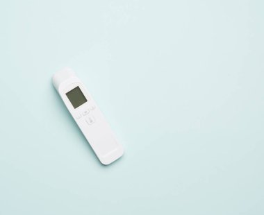 Plastik beyaz elektronik temas olmayan termometre, mavi arkaplan, kopyalama alanı