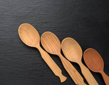 boş tahta kaşıklar siyah arka planda, üst görünümde