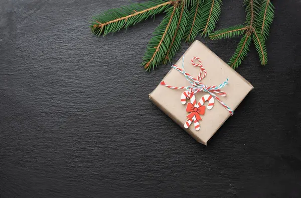 hediye kutusu ve siyah zemin üzerinde yeşil iğne dalları, şenlikli Noel arkaplanı, kopyalama alanı