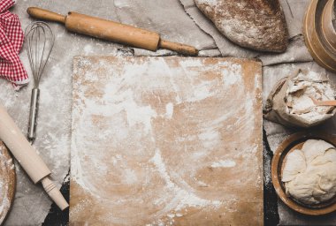 Kurutulmuş ekmek, beyaz buğday unu, ahşap merdane ve masanın üstünde eski bir kesim tahtası.