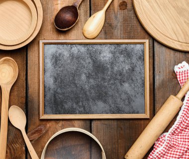 boş siyah çerçeve ve ahşap mutfak vintage eşyalar: elek, merdane, boş kaşık ve yuvarlak tabaklar kahverengi ahşap masa, üst görünüm