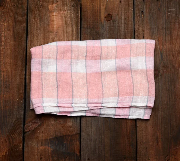 Gevouwen Roze Witte Keukendoek Bruine Houten Achtergrond Bovenaanzicht — Stockfoto