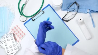 Doktor ellerine mavi lateks eldiven takar ve mavi bir kalem alır. Doktorun terapistinin çalışma alanına en iyi bakış açısı, yavaş çekim. 