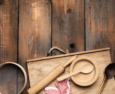 çok eski ahşap mutfak vintage eşyalar: elek, merdane, boş kaşık ve yuvarlak tabaklar kahverengi ahşap masa, üst görünüm