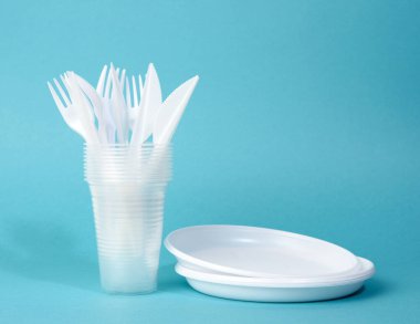 Tek kullanımlık plastik sofra takımı, fincanlar, çatallar ve bıçaklar mavi arka planda, piknik seti