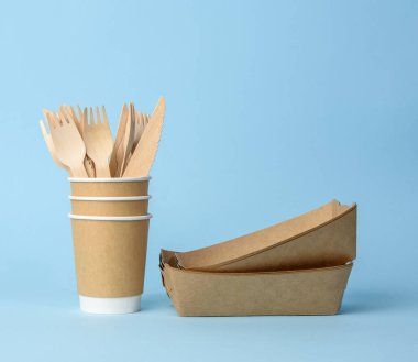 Kahverengi kağıt bardak, plakalar mavi arka planda. Plastik reddetme konsepti, sıfır atık