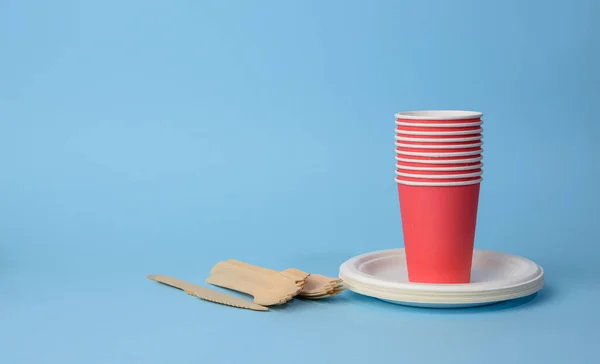 Taza Papel Rojo Platos Blancos Tenedores Cuchillos Madera Sobre Fondo —  Fotos de Stock