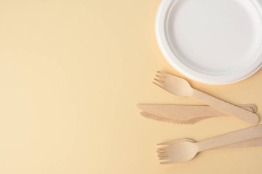 Ahşap çatal ve kahverengi geri dönüşümlü malzemeden yapılmış boş yuvarlak kahverengi tek kullanımlık tabak. Geri dönüşümsüz çöp yokluğu kavramı, plastiğin reddi