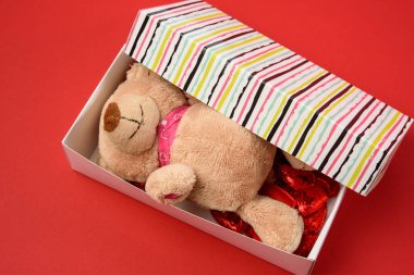 kahverengi ayıcık ve kırmızı tekstil küçük kalpler kırmızı arka planda, şenlikli arka plan, üst manzara