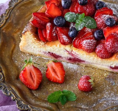 Süzme peynirden yapılmış cheesecake ve tepside taze çilek.