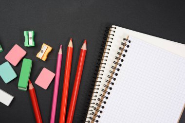 Renkli tahta kalemler, boş bir tebeşir tahtasında not defterleri, okul kağıtları, okula dönüş. 