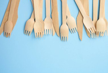 Mavi arka planda tahta çatal ve bıçaklar, sıfır atık, boşluğu kopyala