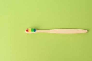 Yeşil zemin üzerinde ahşap diş fırçası, sıfır atık, üst görünüm