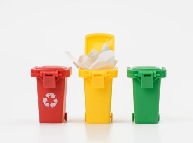 Beyaz arka planda üç adet çok renkli plastik kap, geri dönüşüm için doğru çöp ayıklama kavramı
