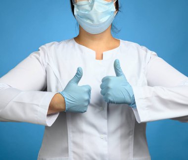 Beyaz önlüklü bir kadın, ellerinde mavi lateks eldivenler, jest, onay konsepti gibi şeyler var.