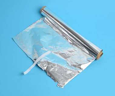 Mavi bir arkaplanda gri folyo rulosu, üstten görünüm