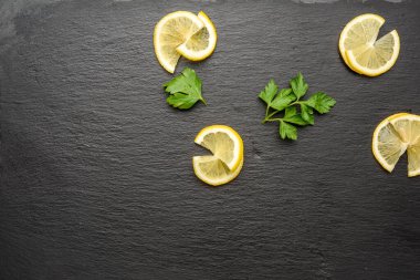 Siyah arka planda dilimlenmiş limon dilimleri, üst manzara.