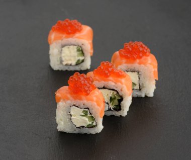 Siyah tahtada kırmızı havyarlı Philadelphia suşisi.