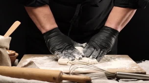 身穿黑色乳胶手套的厨师将白面粉面团揉碎在木板上 准备披萨面团 — 图库视频影像