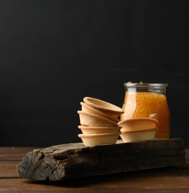 Cam bir kavanozda turta ve siyah arka planda turta, yakın plan.