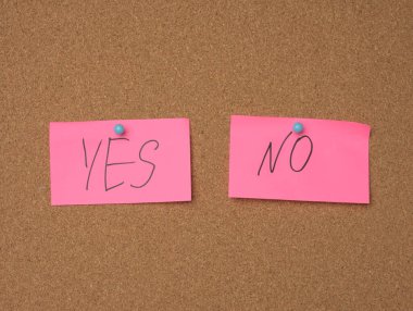 İki pembe çarşaf kahverengi bir mantar panoda asılı. Yazı evet, hayır, kapat.