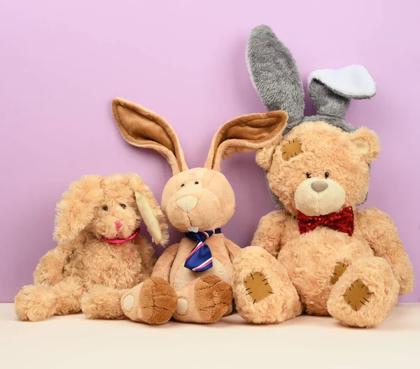 teddy bear in a cap and a cute teddy hare with long ears, a red butterfly tied around his neck, close up