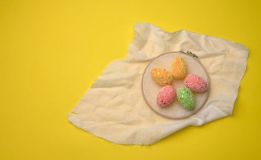 Sarı zemin üzerinde dekoratif paskalya yumurtaları, üst görünüm, kopyalama alanı