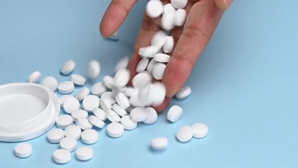 Białe Okrągłe Tabletki Spadające Kobiecej Ręki Niebieskim Tle Zwolnione Tempo — Wideo stockowe