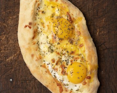 Ahşap tahtada yumurta sarısı ile pişirilmiş Adjarian Khachapuri, geleneksel yemek.