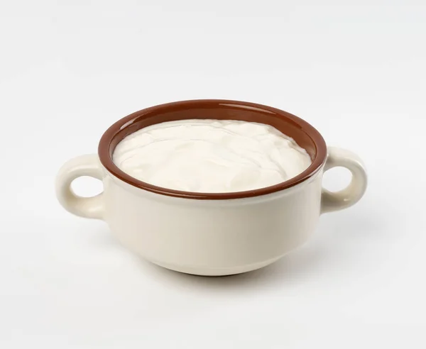 在一个白色底色的褐色陶瓷碗里放酸奶油 发酵过的乳制品 上视图 — 图库照片