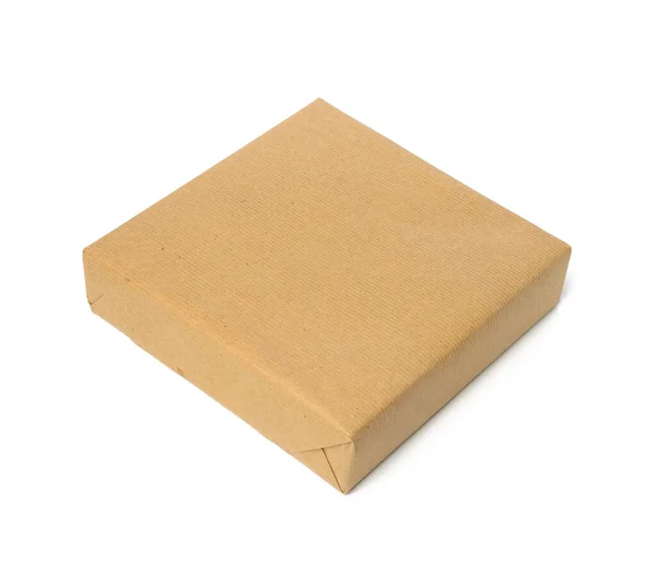 正方形の箱は茶色のクラフト紙に包まれ白い背景に隔離された包装 — ストック写真