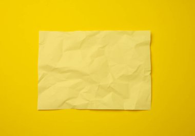 Sarı zemin üzerinde buruşuk sarı kağıt, kopyalama alanı. A4 biçimi