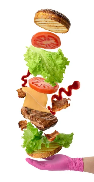 起泡配料芝士汉堡芝麻面包 炸牛排 绿色沙拉和西红柿片 白底粉红手套里的三明治 — 图库照片