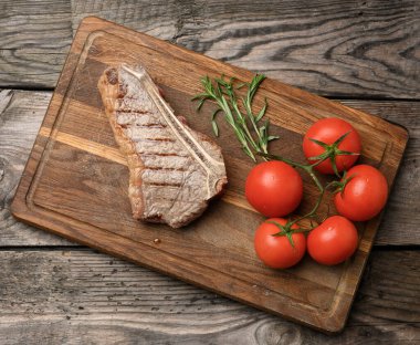 New York bifteği kızartılmış, ahşap kesim tahtasında çizgili, az pişmiş.