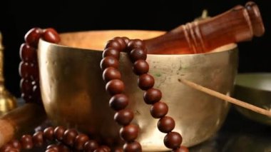 Kahverengi ahşap masa üzerinde ahşap bir çırpıcıyla Tibet 'te şarkı söyleyen bakır kâse meditasyon ve alternatif tıp aletleri.