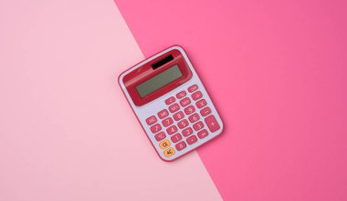 Pembe arka planda pembe plastik hesap makinesi, üst görünüm