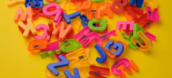 Mehrfarbige Englische Buchstaben Aus Plastik Mit Magnet Auf Gelbem Hintergrund — Stockfoto