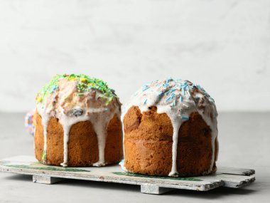 Paskalya bayramı için geleneksel Hristiyan tatlısını pişirdim. Pastalar çok renkli süslemeler ve beyaz arkaplan ile kaplanmış.