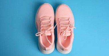 Mavi arka planda bağcıkları olan pembe kadın ayakkabıları, üst manzara, pankart