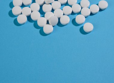 Sağlık hizmetleri için beyaz yuvarlak hap. Tıbbi tedavi, mavi arkaplan, kopyalama alanı