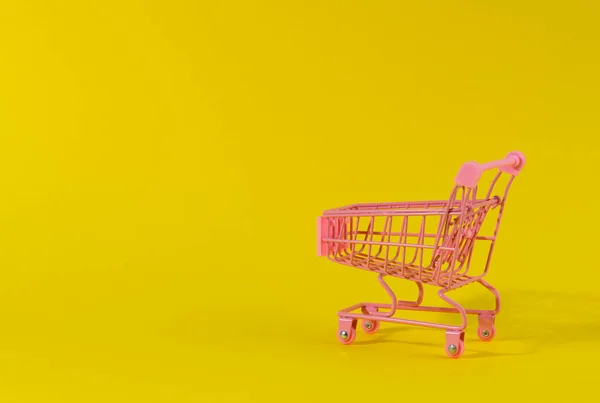 Carrello Della Spesa Miniatura Rosa Vuoto Sfondo Giallo Vendita Stagionale — Foto Stock