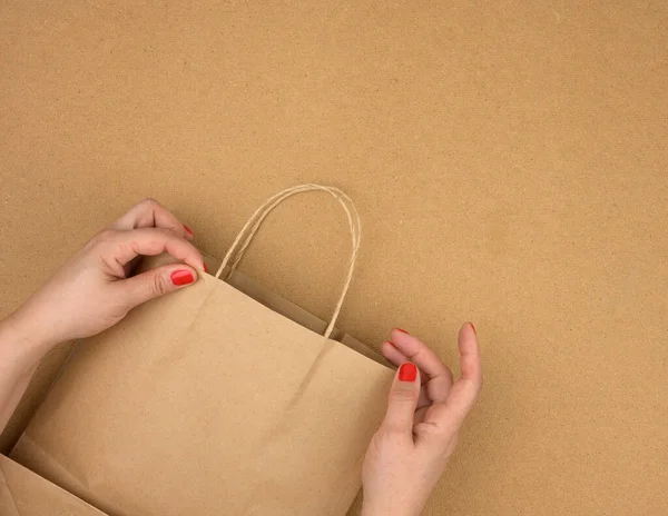 Mano Femenina Sostiene Una Bolsa Papel Marrón Vacía Por Las — Foto de Stock