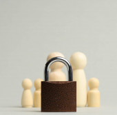 metal lock and a family of wooden figures on a gray background. Security concept, personal data, closed private information for the public