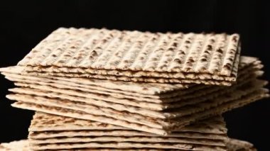 stack of baked square matzo rotate on black background, kosher food