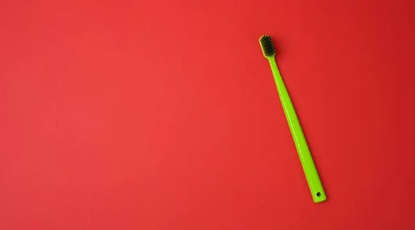 Green Plastic Toothbrush Isolated Red Background Hygiene Product Copy Space — Foto de Stock