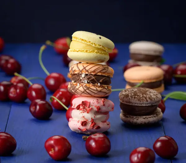 Stack Multicolored Macarons Ripe Red Cherries Blue Wooden Background — Stock Photo, Image