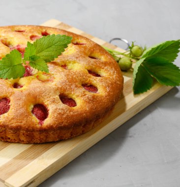 Tahta üzerinde çilek olan yuvarlak sünger pastası.